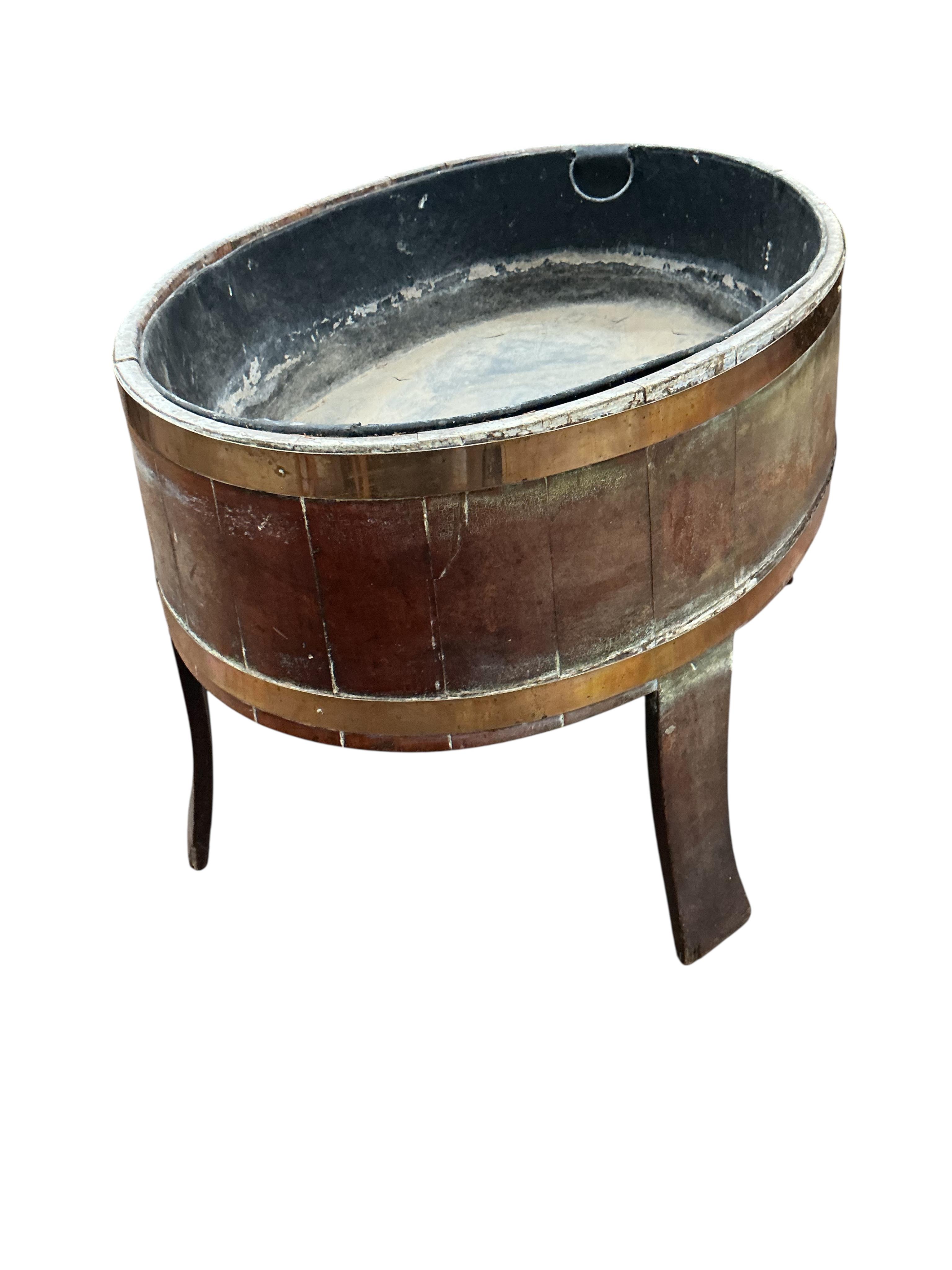 A George III brass bound staved mahogany oval wine cooler, width 92cm, depth 65cm, height 56cm